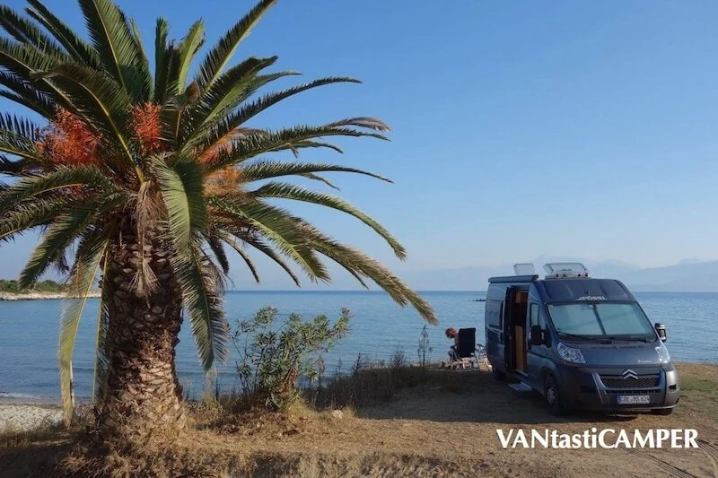 Kastenwagen-Wohnmobil von Pössl steht neben einer Palme am Meer