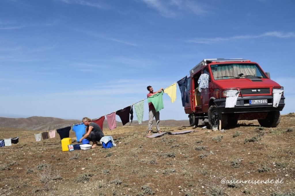 Kastenwagen mit Wäscheleine und Wäsche in der Wüste
