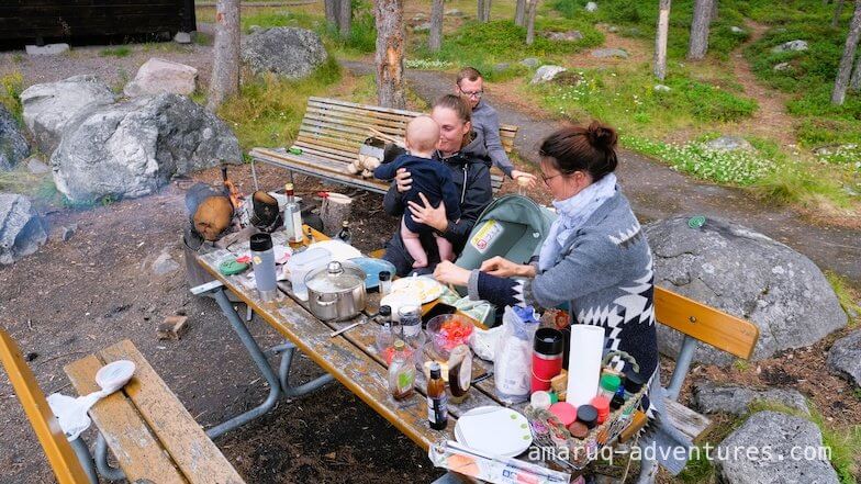 Zwei Frauen sitzen an einem Picknicktisch und kochen