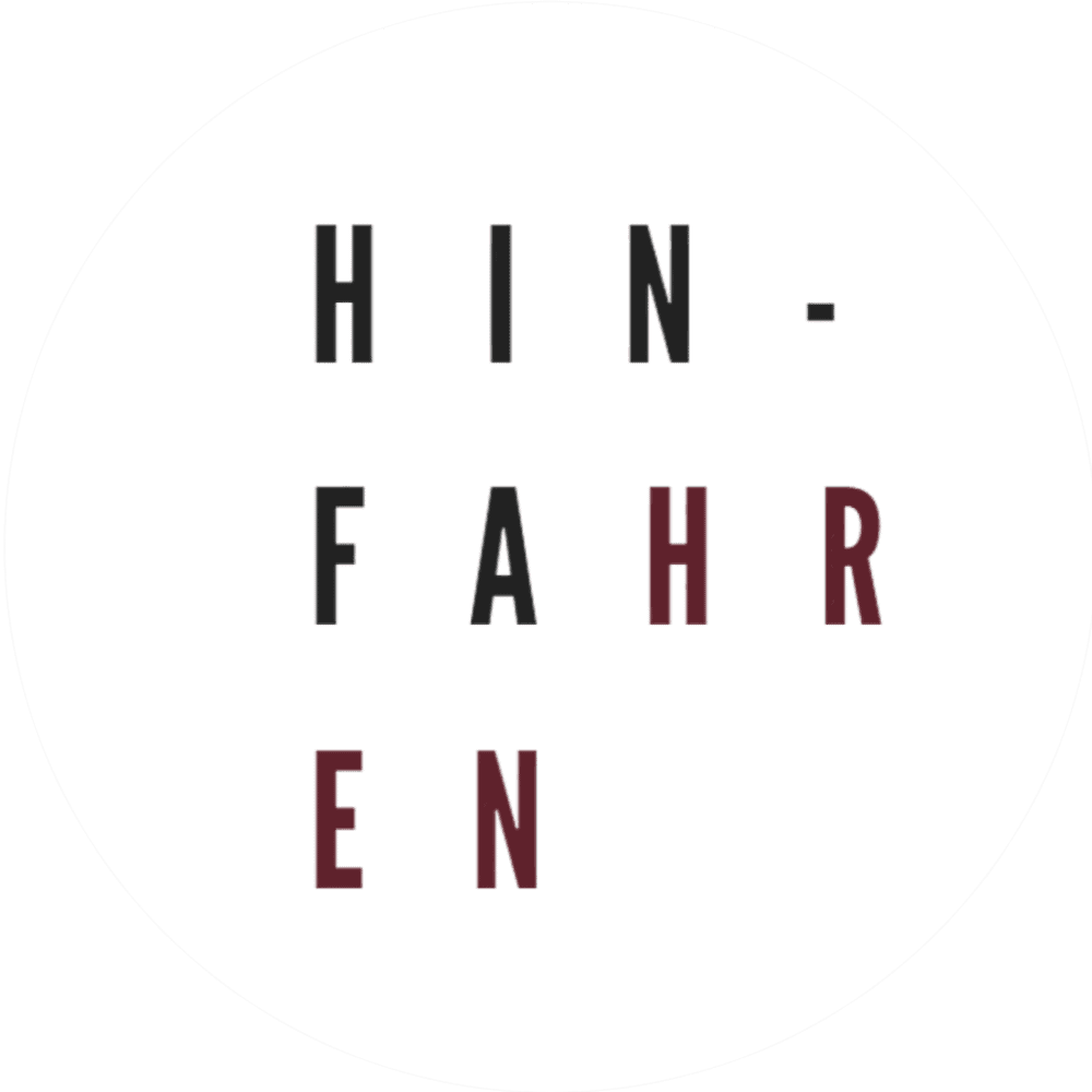 Das Bild zeigt das Wort „HINFHAREN“, aufgeteilt in drei Zeilen: „HIN-“, „FAHR“ und „EN“ auf weißem Hintergrund. Die Buchstaben „R“ und „E“ sind dunkelrot, während die übrigen schwarz sind.