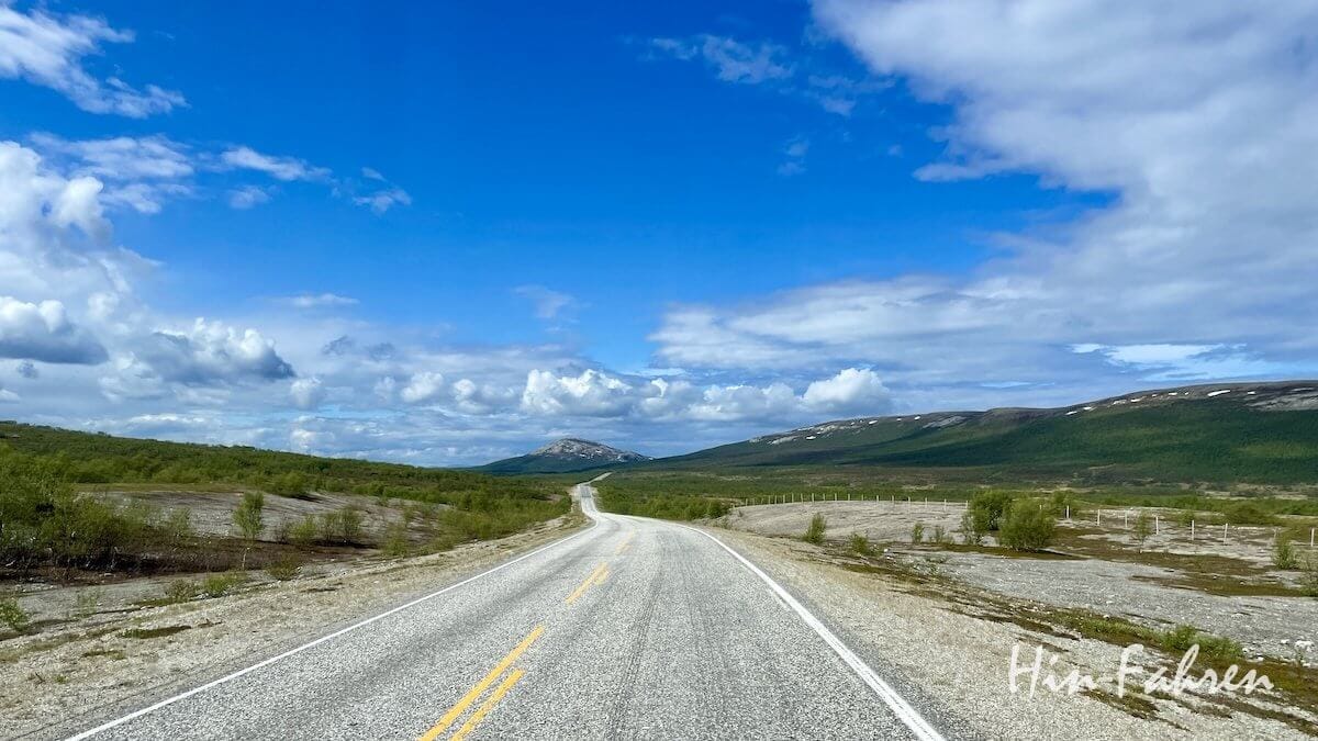 Traumstraße in Norwegen – asphaltierte Landschaftsroute durch grüne Hügel unter blauem Himmel.