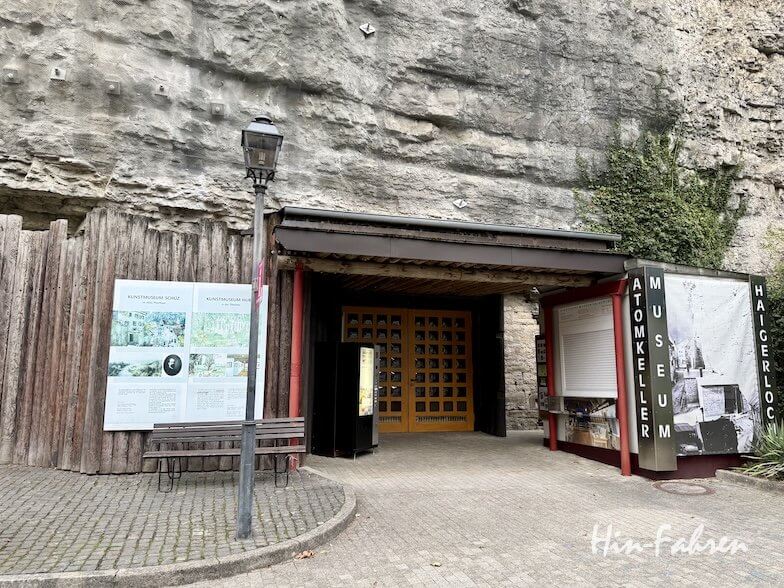 Der Eingang zum Atomkeller-Museum, das in einen Felsen nahe der Hohenzollernstraße eingebaut ist, ist mit Holztüren und Informationstafeln versehen.