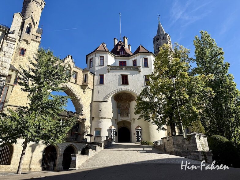 Das Eingangstor und die weißen Türme von Schloss Paffendorf unter blauem Himmel, erreichbar über die Hohenzollernstraße.