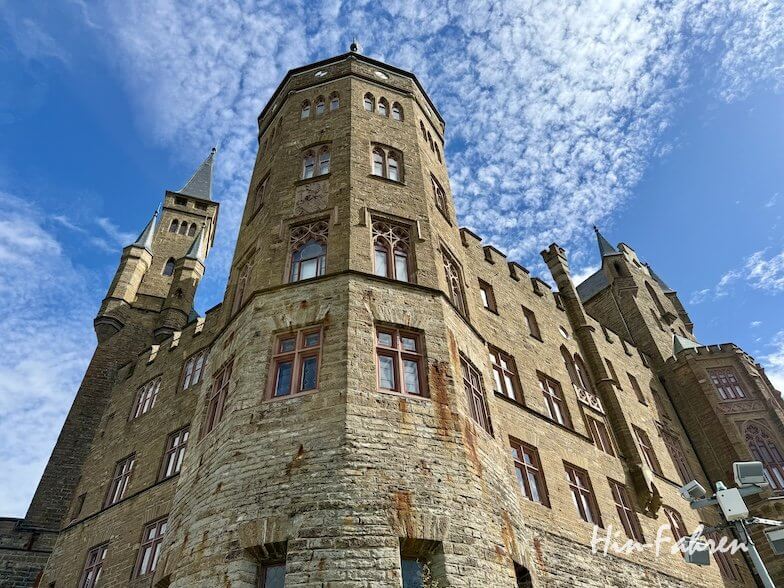 Aufnahme aus niedriger Perspektive einer großen Steinburg mit mehreren Türmen vor blauem Himmel mit vereinzelten Wolken, aufgenommen aus einem Wohnmobil in der Hohenzollernstraße.